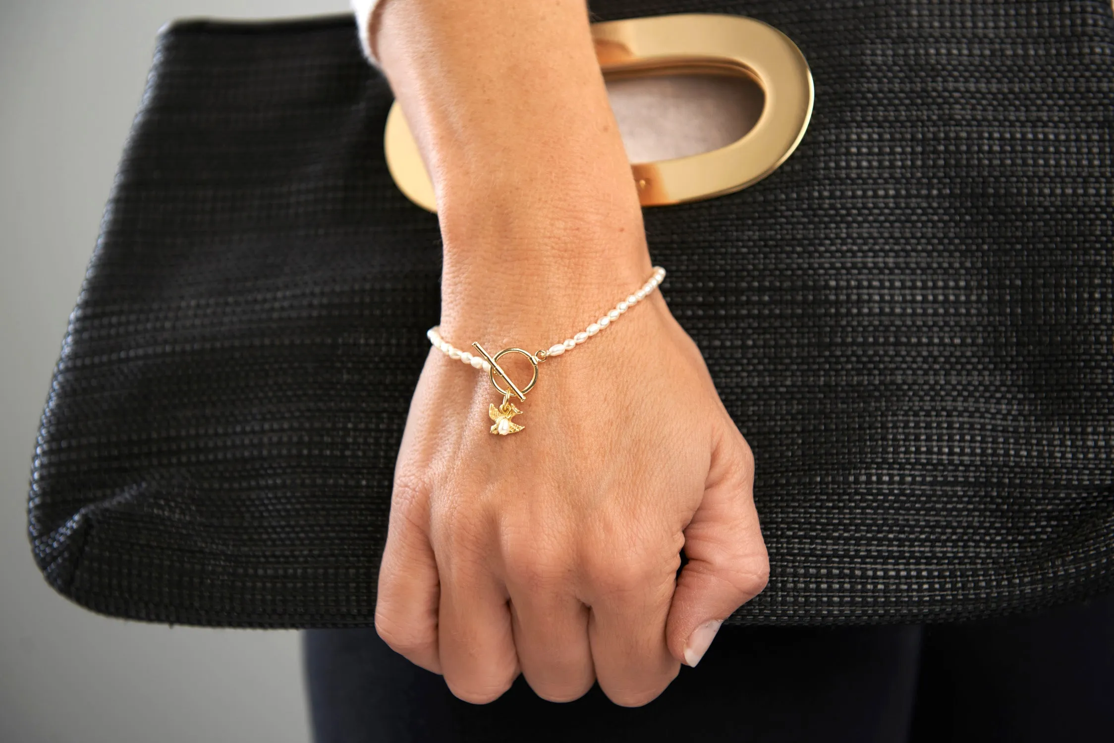 Vita cultured freshwater oval pearl bracelet with a gold-plated swallow charm